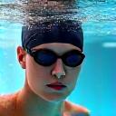 수영 모자를 쓴 수영 선수가 물속에서 스트로크를 하고 있는 모습